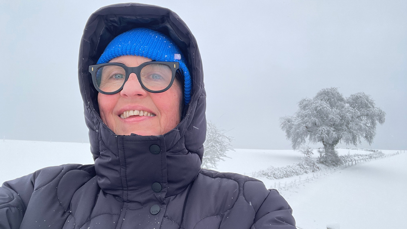 Marianne im Schnee mit verschneitem Baum im Hintergrund
